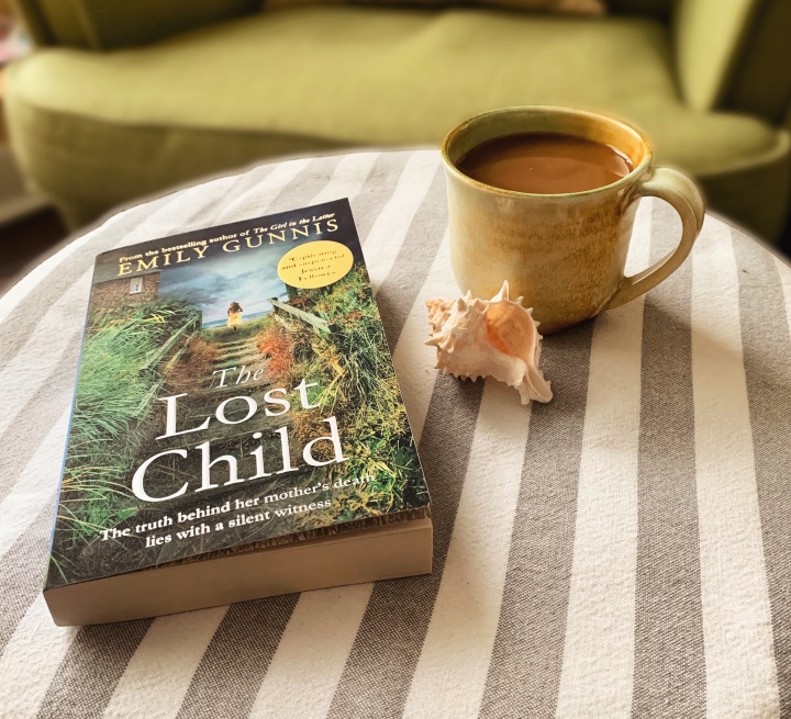 The book The Lost Child lying on an ottoman next to a mug of coffee 
